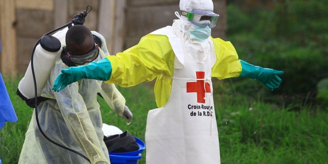 Sept 9, 2018: A health worker sprays disinfectant on his colleague after working at an Ebola treatment center in Beni, eastern Congo.