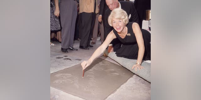 Doris Day signs her name in cement by her handprints on Jan. 19, 1961 on Hollywood Boulevard, Hollywood, California. (Photo by Hulton Archive/Getty Images)