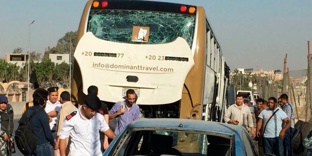 Police inspect a car and a bus that were damaged by a bomb, in Cairo, Egypt, Sunday, March 19, 2019.