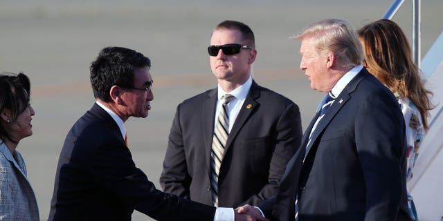 U.S. President Donald Trump, right, is greeted by Japanese Foreign Minister Taro Kono, left, on Trump's arrival at the Haneda International Airport Saturday, May 25, 2019, in Tokyo. (Associated Press)