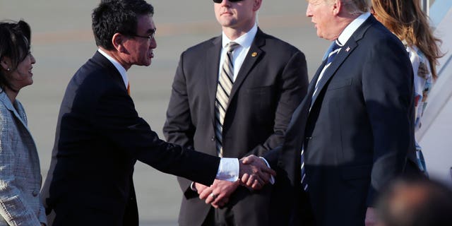 U.S. President Donald Trump, right, is greeted by Japanese Foreign Minister Taro Kono, left, on Trump's arrival at the Haneda International Airport Saturday, May 25, 2019, in Tokyo. (Associated Press)