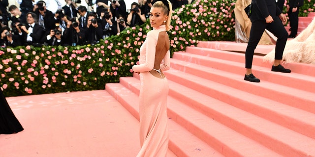 Hailey Baldwin dons a pink sequin Alexander Wang gown with a large cut-out back at The Metropolitan Museum of Art's Costume Institute benefit gala celebrating the opening of the "Camp: Notes on Fashion" exhibition on Monday, May 6, 2019, in New York.