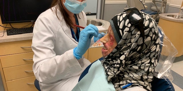 Syrian burn victim Hamama offers a rare smile as she is fitted for a new prosthetic nose by UCLA's Dr. Christine Fortmann in Los Angeles, CA.