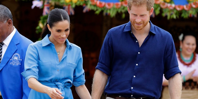 Britain's Prince Harry and Meghan, Duchess of Sussex smile during a visit to Tupou College in Tonga, Friday, Oct. 26, 2018. Prince Harry and his wife Meghan are on day eleven of their 16-day tour of Australia and the South Pacific. (AP Photo/Kirsty Wigglesworth, pool)