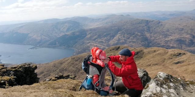 Carried in a pack by either Deborah or partner Scott Mills, 33, Lara has now been up 13 hills and mountains in Scotland, most recently Ben Vrackie in Perthshire, where they walked on Saturday.