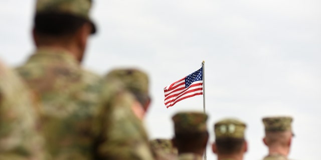 American soldiers and the U.S. flag are pictured. A new research paper released this week highlights the number of suicides in the U.S. military (iStock)