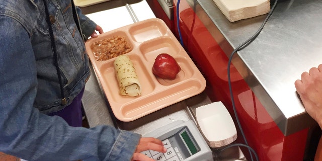 In this Thursday, May 4, 2017 photo, a third-grader punches in her student identification to pay for a meal at Gonzales Community School in Santa Fe, N.M.