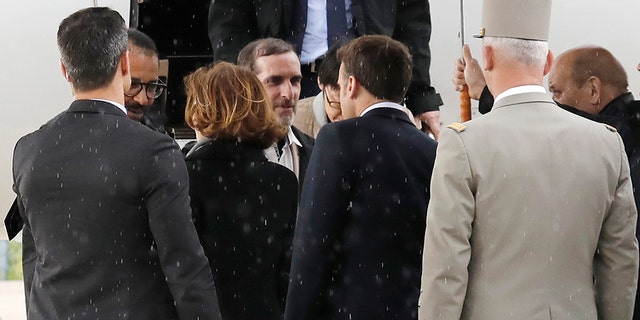 Freed French hostages Laurent Lassimouillas, left, and Patrick Picque, 2nd right, are welcomed by French President Emmanuel Macron, right, and Defense and Minister Florence Parly, 2nd left, at Villacoublay's military airport, west of Paris, France, Saturday, May 11, 2019. Officials said two French special forces officers and four "terrorists" were killed in Friday's pre-dawn military operation in northern Burkina Faso.
