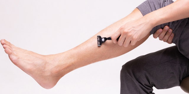 A man shaves his legs (iStock)