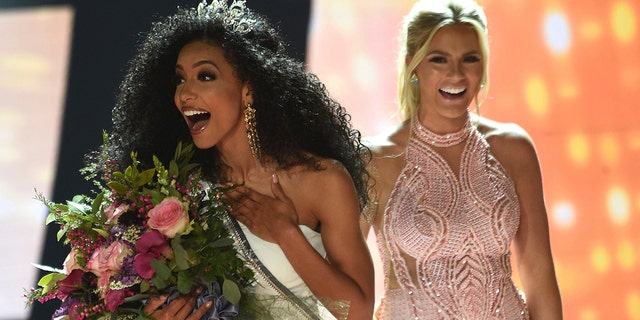 Miss North Carolina Cheslie Kryst, left, gets crowned by last year's winner Sarah Rose Summers, right, after winning the 2019 Miss USA final competition in the Grand Theatre in the Grand Sierra Resort in Reno, Nev., on Thursday, May 2, 2019. (Jason Bean/The Reno Gazette-Journal via AP)