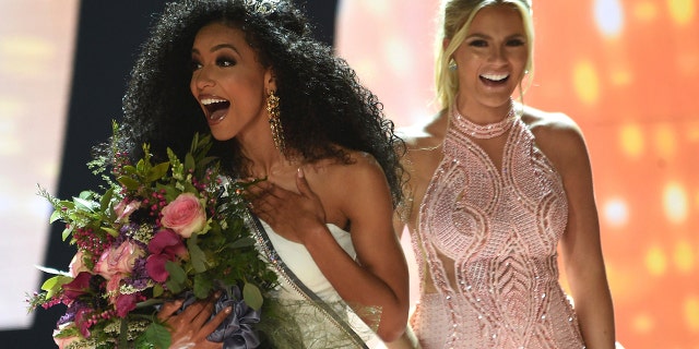Miss North Carolina Cheslie Kryst, left, gets crowned by last year's winner Sarah Rose Summers, right, after winning the 2019 Miss USA final competition in the Grand Theatre in the Grand Sierra Resort in Reno, Nev., on Thursday, May 2, 2019. (Jason Bean/The Reno Gazette-Journal via AP)