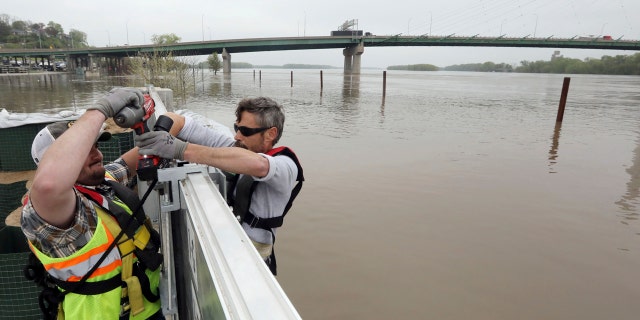 Burlington City workers Chadley Kilbride, left and Will Buhmeyer secure the upright beams for a portion of the expanded flood wall, while secured in harnesses Wednesday May 1, 2019 along the Mississippi Riverfront in Burlington, Iowa.