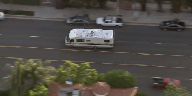 A suspect was in custody Tuesday following a high-speed pursuit involving a mobile home in Southern California. At one point, a dog was seen tumbling out of the badly damaged vehicle but appeared to walk away unscathed.