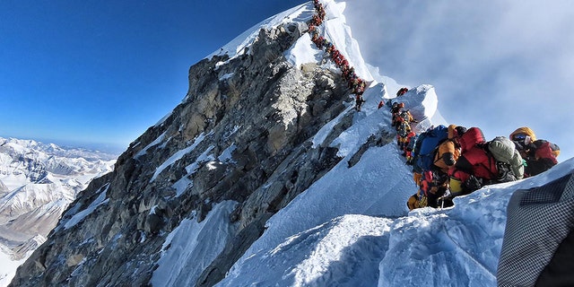 A line of climbers attempt to stand at the summit of Mount Everest. A British climber, Robin Haynes died on the mountain on Saturday.