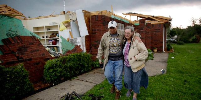 Karen Spencer is helped to her storm cellar by her daughter Tammi Foster in Peggs, Okla. Tuesday, May 21, 2019. Spencer's home was hit by an apparent tornado on Monday night.
