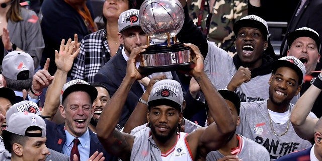 Toronto Raptors forward Kawhi Leonard (2) holds up the trophy after the team's 100-94 win over the Milwaukee Bucks in Game 6 of the NBA basketball playoffs Eastern Conference finals Saturday, May 25, 2019, in Toronto.