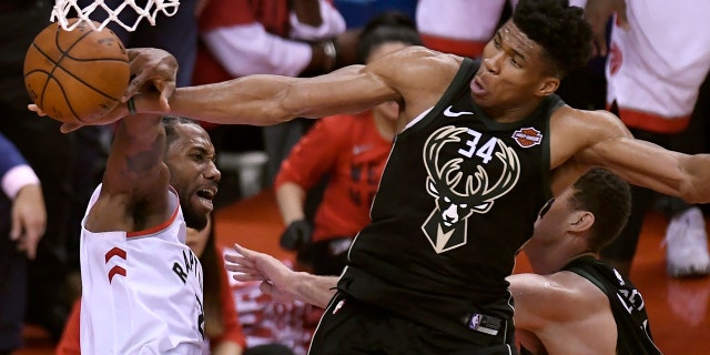 Milwaukee Bucks forward Giannis Antetokounmpo (34) blocks a dunk attempt by Toronto Raptors forward Kawhi Leonard, left, during the second half of Game 6 of the NBA basketball playoffs Eastern Conference finals Saturday, May 25, 2019, in Toronto.