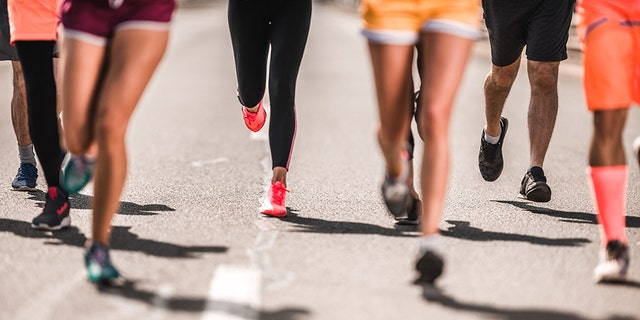 Unrecognizable athletic people running a marathon on the road.