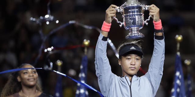 Naomi Osaka of Japan holds the trophy after defeating Serena Williams in the women's U.S. Open tennis final on Saturday, September 8, 2018 in New York. (Associated Press)