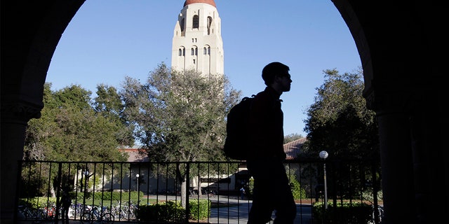 A Stanford University student walks in front of Hoover Tower on the Stanford University campus in Palo Alto, Calif.