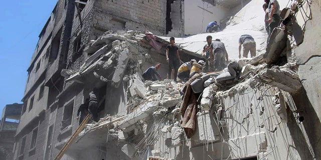 This photo provided by the Syrian Civil Defense White Helmets, which has been authenticated based on its contents and other AP reporting, shows Civil Defense workers inspecting a damaged building after an airstrike by Syrian government forces, in the town of Ariha, in the northwestern province of Idlib, Syria, Monday, May 27, 2019.