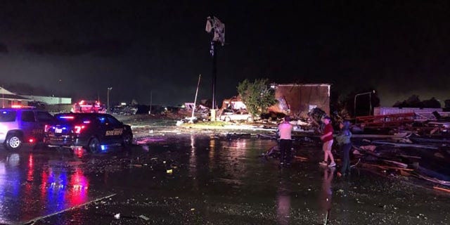 People look over heavy tornado damage in El Reno, Okla., on Saturday night. (FOX 25, Oklahoma City)