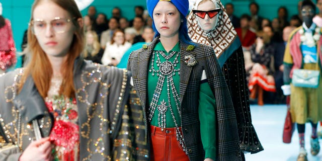 FILE - In this Feb. 21, 2018 file photo, models display items from Gucci's women's Fall/Winter 2018-2019 collection, presented during the Milan Fashion Week, in Milan, Italy. The top civil rights organization for Sikhs in the United States says Nordstrom has apologized to the community for selling an $800 turban they found offensive, but they are still waiting to hear from the Gucci brand that designed it, Saturday, May 18, 2019. (AP Photo/Antonio Calanni, File)