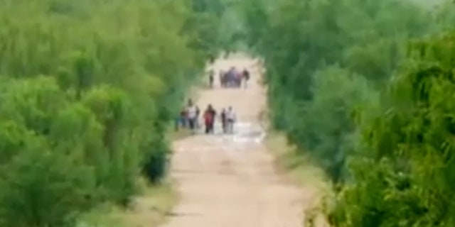 We see migrants walking on a road to a part of the US-Mexico border that a senior official calls for 