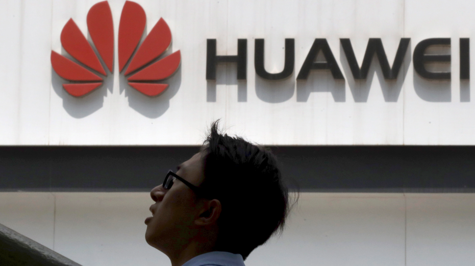 In this photo taken Thursday, May 16, 2019, a man past by a Huawei store in Beijing. Google is assuring users of Huawei smartphones the American company's services still will work on them following U.S. government restrictions on doing business with the Chinese tech giant. (AP Photo/Ng Han Guan)