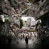 A tourist takes pictures in the entrance way to a shopping mall decorated with mirrors in Tokyo, May 18, 2019.