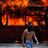An anti-government protester walks near a bus that was set on fire by opponents of Venezuela's President Nicolas Maduro during clashes between rebel and loyalist soldiers in Caracas, Venezuela, April 30, 2019. 