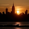 The sun rises behind the Empire State Building, Chrysler Building in New York City, May 25, 2019.