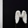 A man walks by a pair of angel wings as part of a store display in Beverly Hills, California, May 7, 2019 