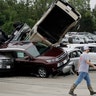 A worker walks past tornado-damaged Toyotas at a dealership in Jefferson City, Missouri, May 23, 2019.