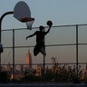 People play basketball in front of the Empire State Building as the sun sets in New York City, May 8, 2019