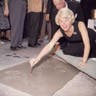 Doris Day signs her name in cement by her handprints, in front of Mann's (formerly Grauman's) Chinese Theater, on Hollywood Boulevard in January 1961.