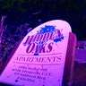 The sign for the Hidden Oaks apartment complex in Jefferson City stands bent from a tornado in front of a tree that was ripped apart. (AP Photo/David A. Lieb)