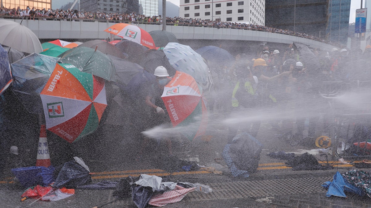 Protesters are hit by police water cannon during a demonstration against a proposed extradition bill in Hong Kong, China June 12, 2019. REUTERS/Tyrone Siu - RC12C6522E40