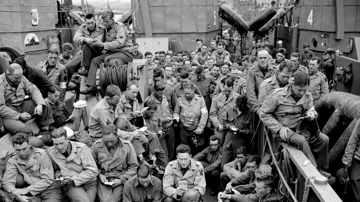 American servicemen huddle on D-Day war ship.