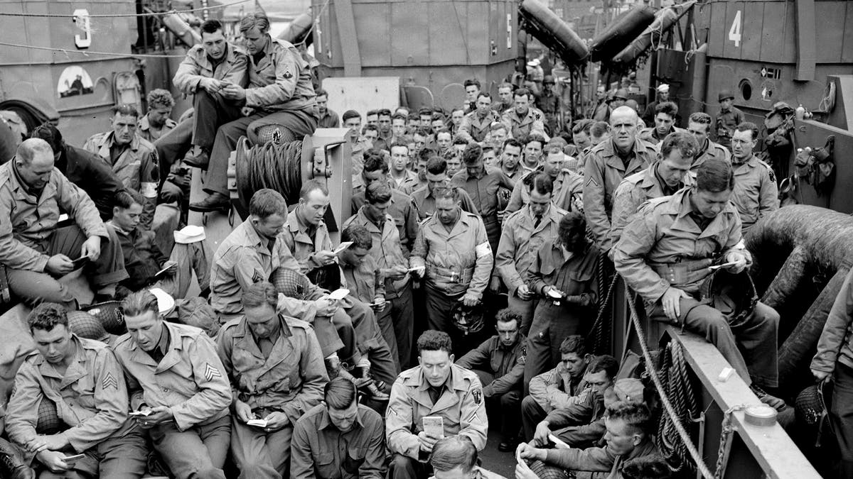 American servicemen huddle on D-Day war ship.