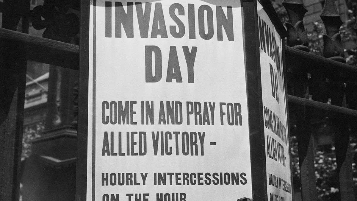 A sign is depicted saying: "Invasion Day: Come in and pray for allied victory - hourly intercessions on the hour."