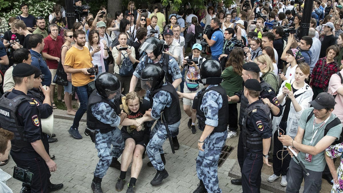 Police officers detain a protester during a march in Moscow, Russia, Wednesday, June 12, 2019. Police and hundreds of demonstrators are facing off in central Moscow at an unauthorized march against police abuse in the wake of the high-profile detention of a Russian journalist.