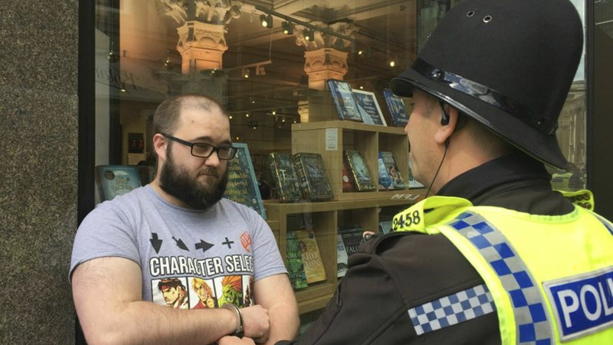 Paul Crowther speaks to police after Brexit Party leader Nigel Farage was hit with a milkshake during a campaign rally in Newcastle, England, Monday May 20, 2019.