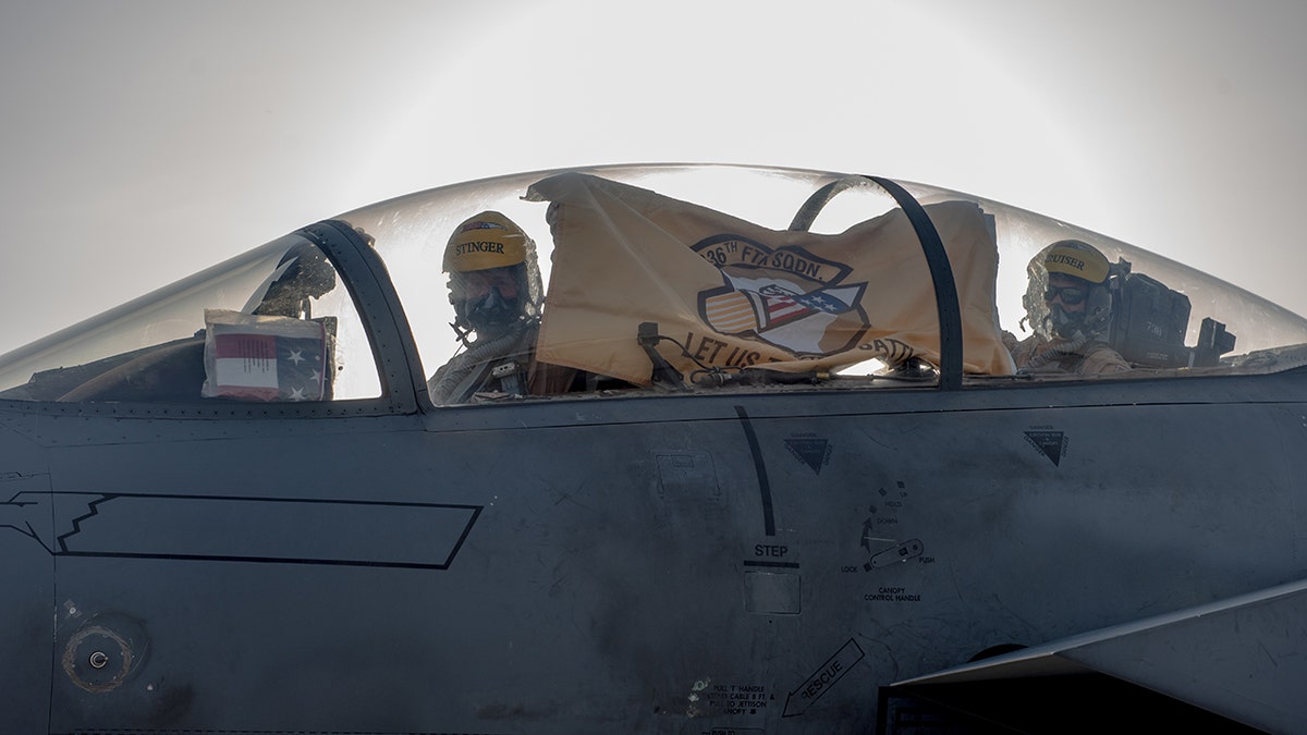 F-15E Strike Eagle aircrew hold up their 336th Fighter Squadron flag, June 13, 2019, at Al Dhafra Air Base, United Arab Emirates. The 336th FS deployed from the 4th Fighter Wing at Seymour Johnson AFB, North Carolina, bringing additional air power to Team ADAB.