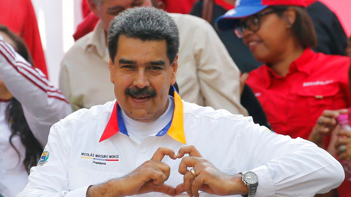 In this May 20 photo, Venezuela's President Nicolas Maduro flashes a hand-heart symbol to supporters outside Miraflores presidential palace in Caracas. (AP Photo/Ariana Cubillos)