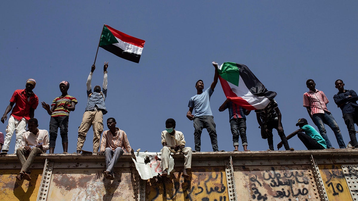 FILE - In this May 2, 2019, file photo, Sudanese protesters wave national flags at the sit-in outside the military headquarters, in Khartoum, Sudan. (AP Photos/Salih Basheer, File)