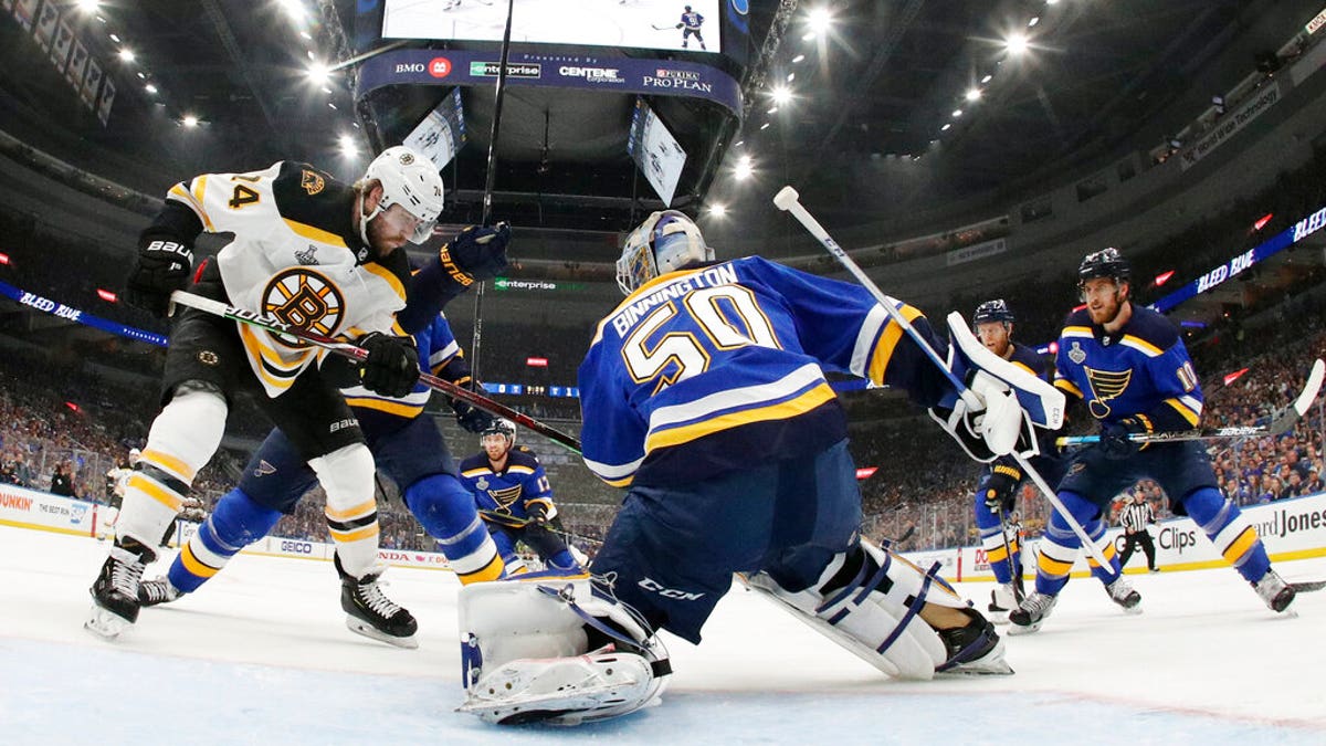 St. Louis Blues goaltender Jordan Binnington (50) catches the puck as Boston Bruins left wing Jake DeBrusk (74) watches for the rebound during the first period in Game 6 of the NHL hockey Stanley Cup Final. A Blues prospect was robbed at gunpoint on the grounds of the Gateway Arch, team officials said Tuesday. (Bruce Bennett/Pool via AP)