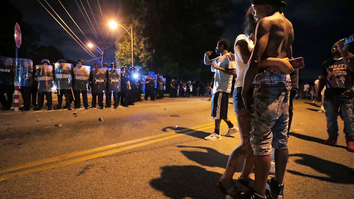 A man identified as Sonny Webber, right, father of Brandon Webber who was reportedly shot by U.S. Marshals earlier in the evening, joins a standoff as protesters take to the streets of the Frayser community in anger against the shooting. (Associated Press)