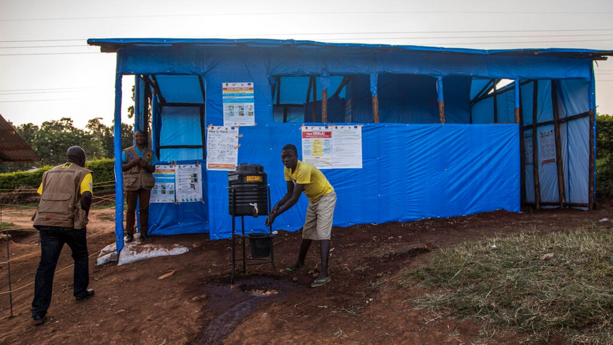 This photo released by the International Rescue Committee (IRC) shows a Congolese refugee boy washing his hands before entering one of the medical tents used for evaluating newly arrived Congolese for potential symptoms of Ebola, at the Kyaka refugee settlement in western Uganda Wednesday, June 12, 2019.