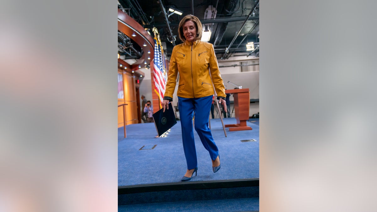An avid sports fan, Pelosi is wearing the colors of the Golden State Warriors colors, a gold jacket with blue pants. (AP Photo/J. Scott Applewhite)